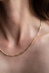 The Tura Sugden Trombone Link Necklace - Heavy rests on a person’s neck and collarbone.