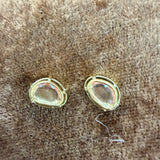 Tura Sugden Pink Spinel Earrings, two ovals with clear stones on a brown textured surface.