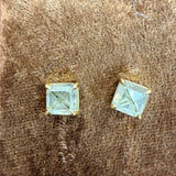 Pair of Tura Sugden Asscher rose cut diamond earrings in recycled 18k gold on brown texture.
