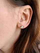 Close-up of an ear with two Tura Sugden Abalone Pearl Earrings: stud and thin gold hoop.