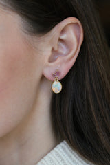 A close-up of a woman’s ear wearing Tura Sugden Opal + Sapphire Earrings.