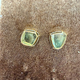 Tura Sugden Diamond Slice Earrings rest on a brown textured surface.