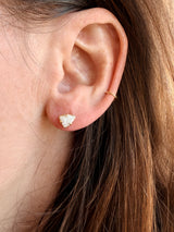 Close-up of an ear with Tura Sugden Angel Wing Pearl Earrings in recycled 18k yellow gold.