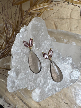 Pair of earrings on a crystal rock with natural background