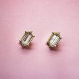 Hexagonal Diamond Earrings by Tura Sugden set in recycled 18k gold on a pink background.